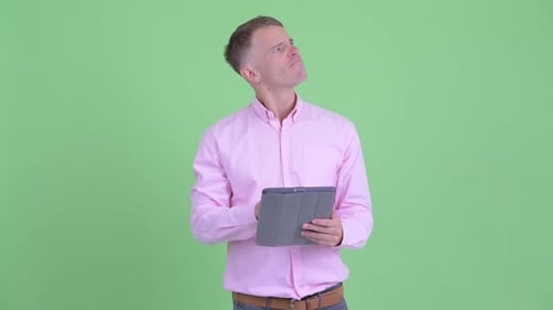 Man with Tablet Thinking and Smiling