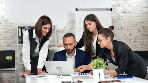 Team Collaborating on Laptop in Modern Office