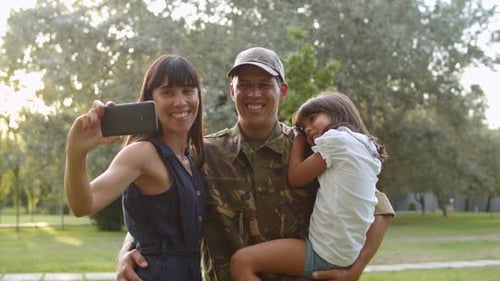 Happy Family Poses for Photo with Soldier Dad