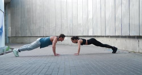 Athletic Couple Doing Pushups and High-Fiving
