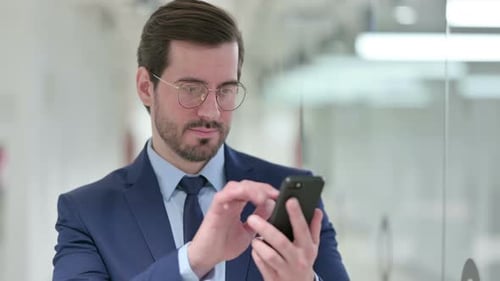 Adult Typing on Smartphone in Office Setting