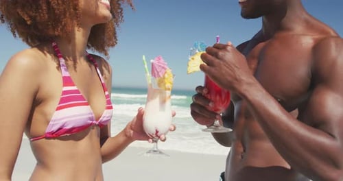 Couple Enjoying Tropical Cocktails on a Sandy Beach