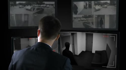 Security Guard in Front CCTV Footage Watching Bank Robbery, Calling Police