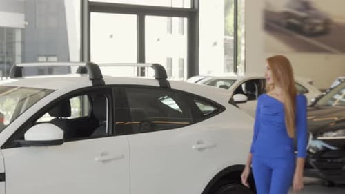 Beautiful Woman Choosing Automobile To Buy at Dealership Salon