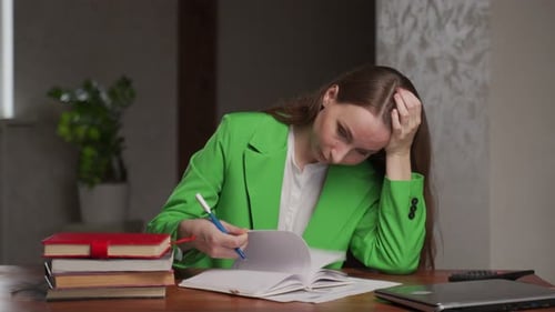 Tired Teacher Checks Homework of Students Sitting at Table