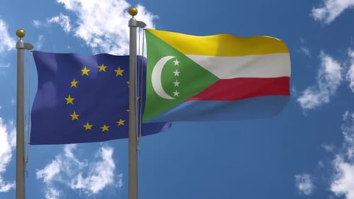 European Union and Comoros Flags Waving in Blue Sky