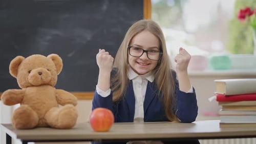 Front View Joyful Satisfied Schoolgirl Gesturing Yes Sitting at Desk in School