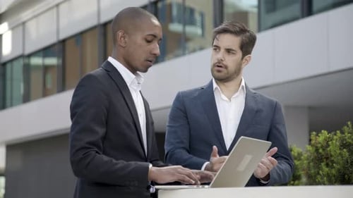Serious Male Colleagues Watching Project Presentation
