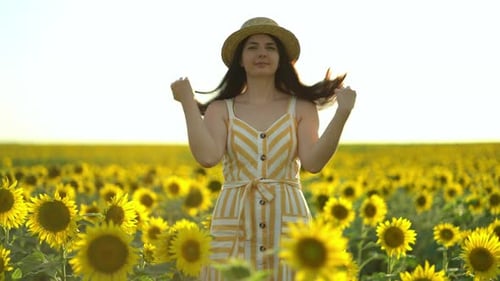 Woman in Sunflower Field Posing with Straw Hat