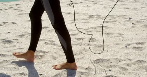 Frau spaziert mit Surfbrett am Strand 4k