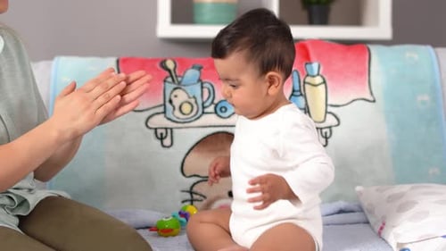 The mother applauds her baby.