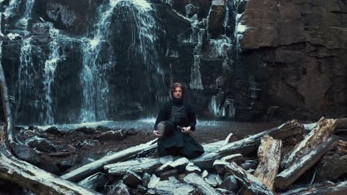 Young Adult with Kendo Gear Near Waterfall