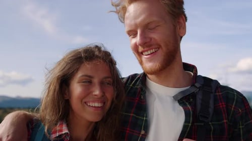 Smiling Couple on Mountain Hike with Backpacks