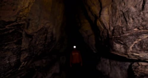 Male hiker exploring a dark cave 4k