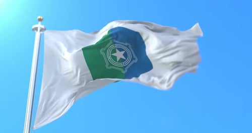 Realistic White, Green, and Blue Flag Waving Against Blue Sky