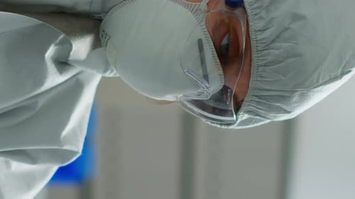 Vertical Video Scientist in Coverall Doing Research Analysing Liquid in Tube