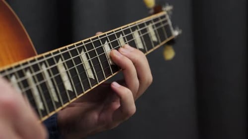 Menschliche Finger spielen auf Gitarre Nahaufnahme von Griffbrett und Saiten