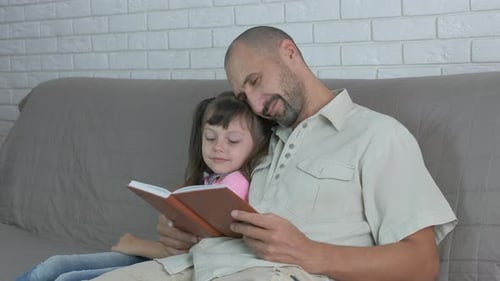 Father Reading a Book to his Daughter