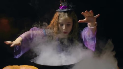Girl Dressed as a Witch Stirring Smoky Cauldron