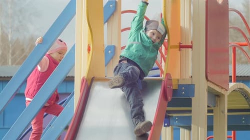 Children Playing on Colorful Suburban Playground Slide