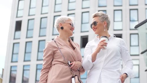 Stylish Women Laughing Outside Modern Building