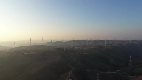 Aerial view of powerful Wind turbine farm for energy production on beautiful cloudy sky at highland.