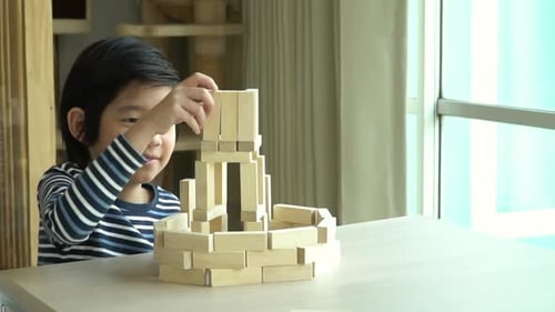 Cute Asian Child Playing Wooden Bolck In The Living Room