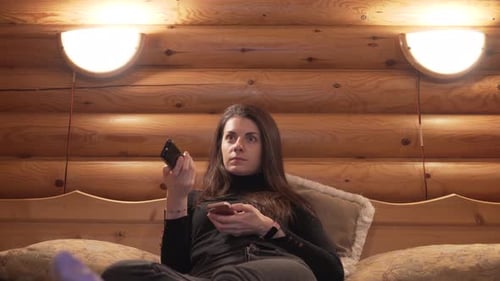 Woman Relaxing on Bed with Phone and Device