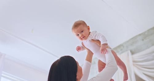 Loving Mother Holds Adorable Baby in the Air