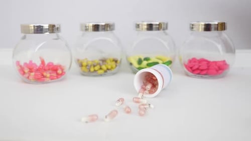 Pills falling out of a bottle in studio