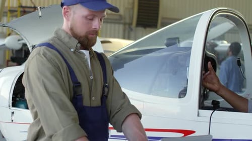 Male Pilot Talking to Aircraft Mechanic