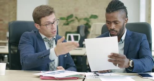 Businessmen Review Documents, Sign Agreement, and Shake Hands