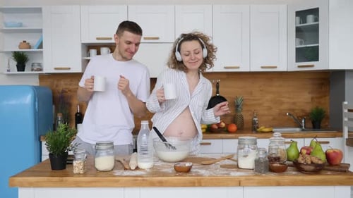 Happy Couple Dancing While Cooking in Kitchen