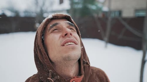 Young Adult Smiling as Snow Lightly Falls