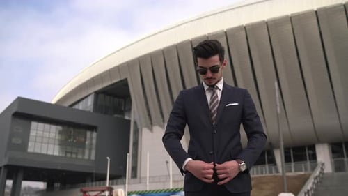 Man in Stylish Suit Buttons Up Outside