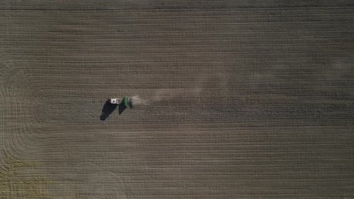 Aerial View of Tractor Tilling Brown Agricultural Field