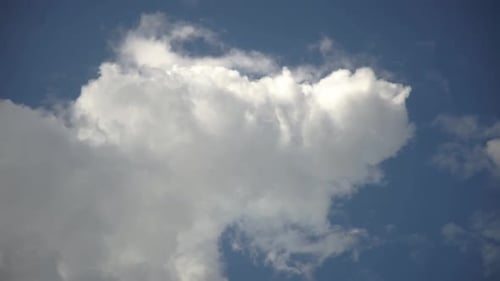 Fluffy White Clouds Drifting in Blue Sky
