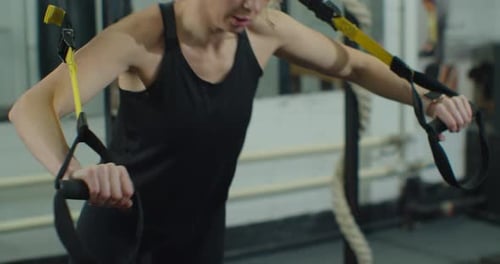 Woman Works out with Resistance Straps at Gym