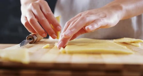 Femme tranchant la pâte sur une planche à découper 4k