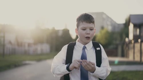 CU, Tracking: Portrait of Schoolboy, with a Knapsack Behind His Back