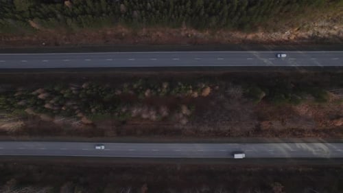 Verkehrsautos auf mehrspuriger Autobahnstraße zwischen tiefem Wald