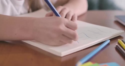 Close-up of Female Caucasian Hands Solving Math Problem in the Exercise Book. Elementary Student