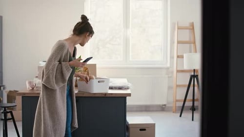 Woman Using Phone in Brightly Lit New Kitchen