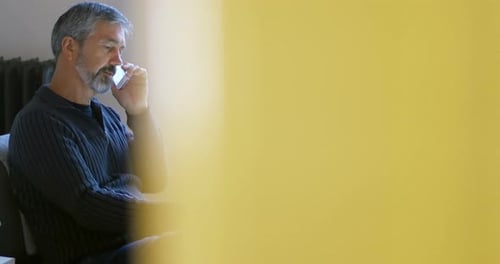 Man talking on phone while using tablet