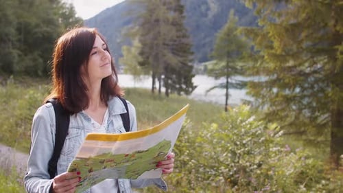 Woman Looking at Map in Nature near Lake