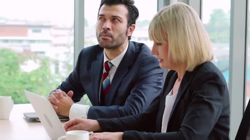 Two Business People Talk Project Strategy at Office