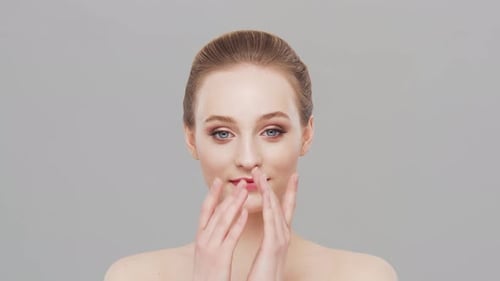 Studio portrait of young, beautiful and natural woman over grey background.