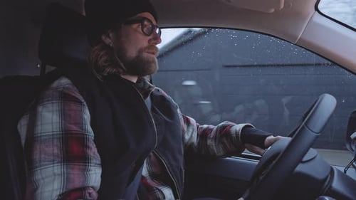 Motorista barbudo em óculos dirigindo no caminhão