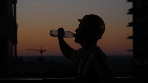 Constructor bebiendo de la botella.
