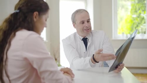 Doctor Explains X-Ray To Patient in Sunny Office